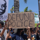 People hold signs during a peaceful Black Lives Matter protest march in Southern California on June 7, 2020.